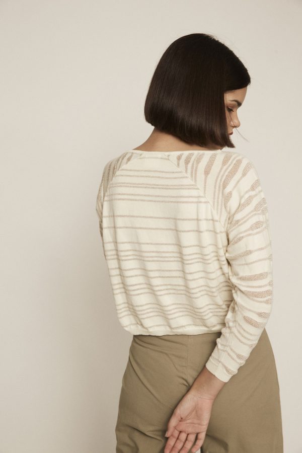 Off-white knit sweater with boat neckline, see-through motifs and elastic cuffs.
